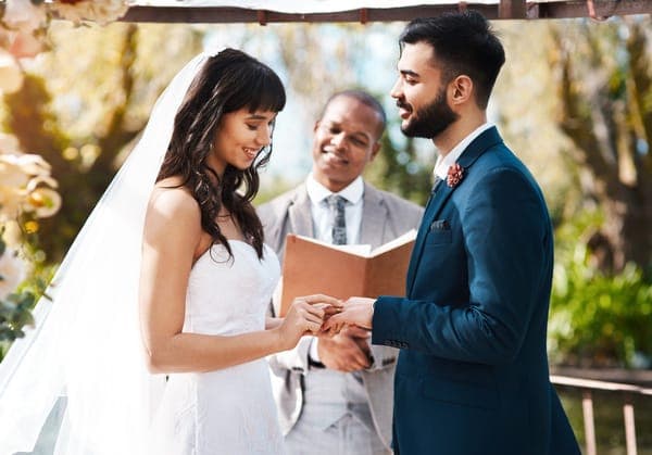 Brautpaar beim emotionalen Ringtausch während der Trauung im Freien, dem absoluten Höhepunkt im Tagesablauf der Hochzeit.