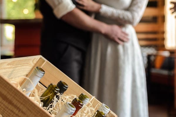 Ehepaar halten Hände zur hochzeit mit einem geldgeschenk aus Weinflaschen