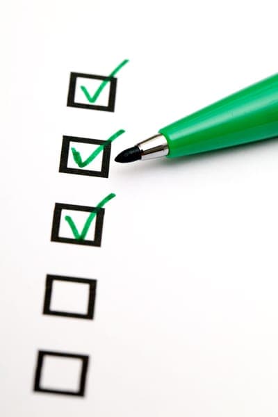 Checkliste mit grünem Stift und abgehakten Kästchen