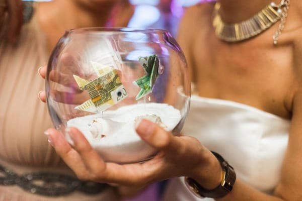 Ein kreatives Geldgeschenk in einer Glasschale, eine originelle Idee für ein Geschenk für die Ehefrau, die auf eine gemeinsame Reise spart.