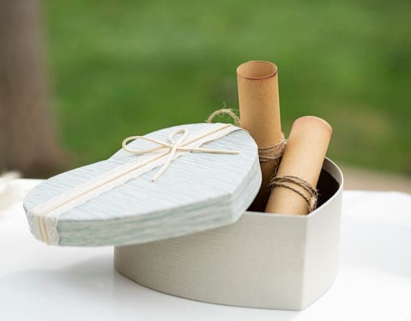 Eine herzförmige Geschenkbox mit persönlichen Botschaften auf kleinen Schriftrollen – ein romantisches, selbstgemachtes Geschenk für die Ehefrau.