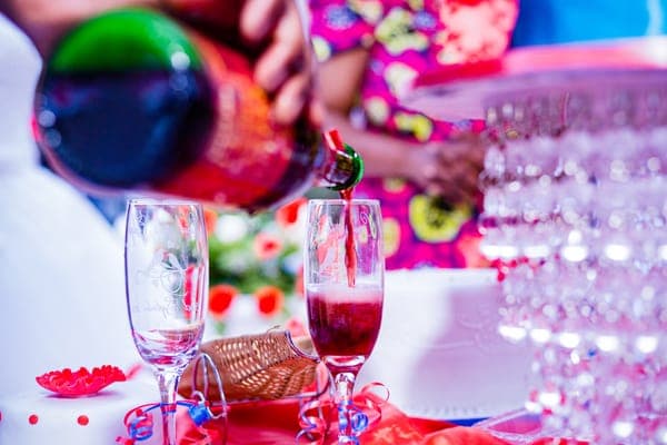Red sparkling wine being poured into a champagne flute on a festively decorated table