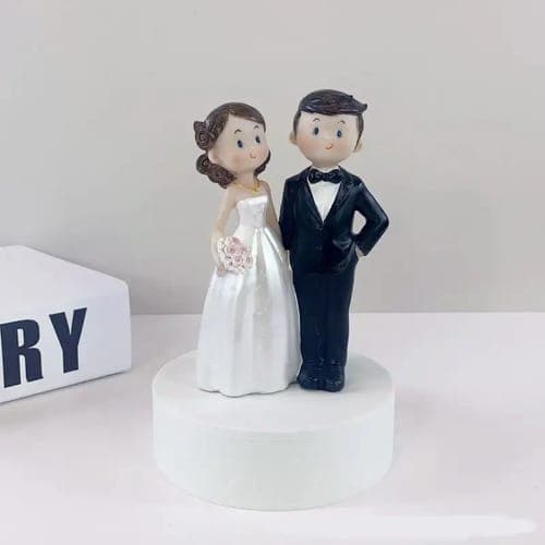Ein klassischer Cake Topper in Form einer Porzellanfigur, die ein Brautpaar darstellt, für einen traditionellen Hochzeit Cake.