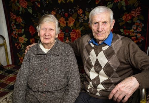 Ein sehr altes Jubelpaar sitzt eng beieinander und symbolisiert die tiefe, unerschütterliche Verbundenheit nach über 67 Ehejahren zur Steinernen Hochzeit.