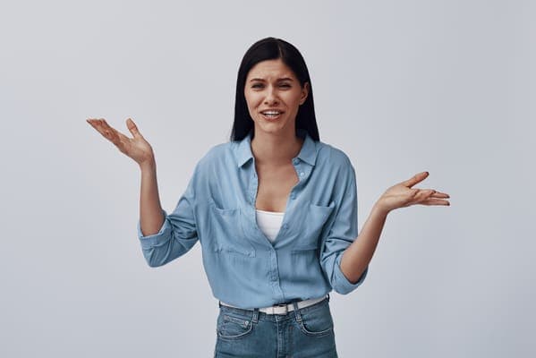 Eine Frau mit fragender Geste, die die Überlegung symbolisiert, wie man am besten die wichtige Frage „Willst du meine Trauzeugin sein?“ stellt.
