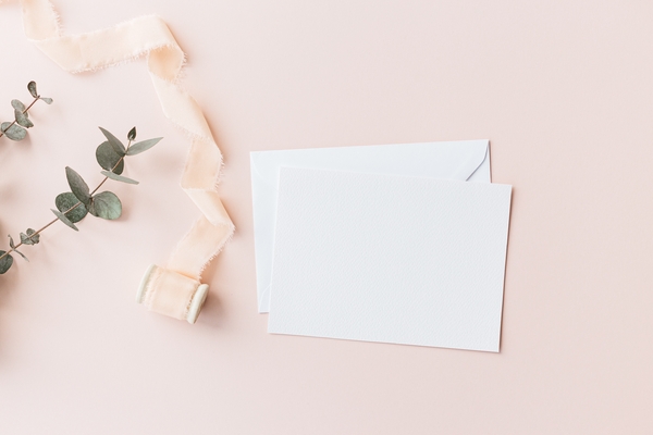 Dankeskarten Hochzeit: Der ultimative Guide für unvergessliche und persönliche Worte Unterhaltung Hochzeit, Hochzeitsblog Blanko-Klappkarte mit Umschlag auf rosafarbenem Hintergrund, Seidenband und Eukalyptus