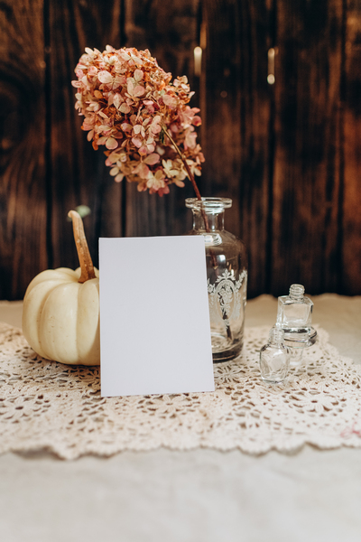 Dankeskarten Hochzeit: Der ultimative Guide für unvergessliche und persönliche Worte Unterhaltung Hochzeit, Hochzeitsblog Rustikale Tischszene mit Kürbis, Vase und Blanko-Karte