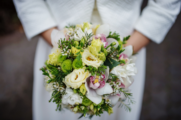 Wie viel kostet eine Hochzeit: Der komplette Guide für die Schweiz Guides Eine Braut hält ihren üppigen Brautstrauss; der Preis für Blumen und Dekoration muss im Budget eingeplant werden und beeinflusst, wie viel eine Hochzeit kostet.