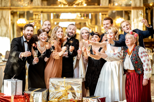 Kristallhochzeit: Der ultimative Guide für euer strahlendes 15. Ehejubiläum Hochzeitsjubiläen, Hochzeitsblog Eine festlich gekleidete Gesellschaft stösst mit Sektgläsern an, um einen besonderen Meilenstein wie die kristallhochzeit zu feiern.