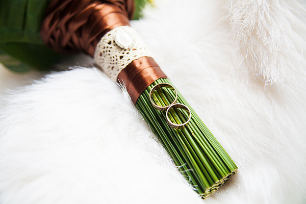 Kupferne Hochzeit: Alles, was du über das glänzende Jubiläum nach 7 Jahren wissen musst Hochzeitsjubiläen, Hochzeitsblog Ein Brautstrauss mit kupferfarbenem Band, an dem die Eheringe befestigt sind – ein passendes Symbol für die Kupferne Hochzeit.