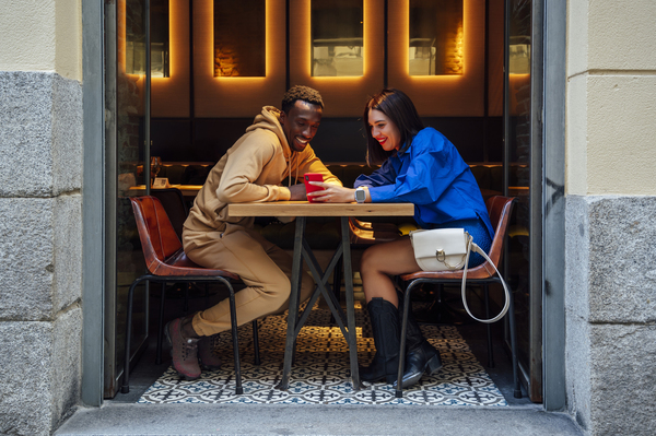 Date Ideen im Herbst - dein umfassender Guide für romantische & aktive Momente in der Schweiz Paare, Hochzeitsblog Date-Ideen Herbst: Paar bei heissem Getränk im gemütlichen Café – warmes Licht, entspanntes Gespräch.