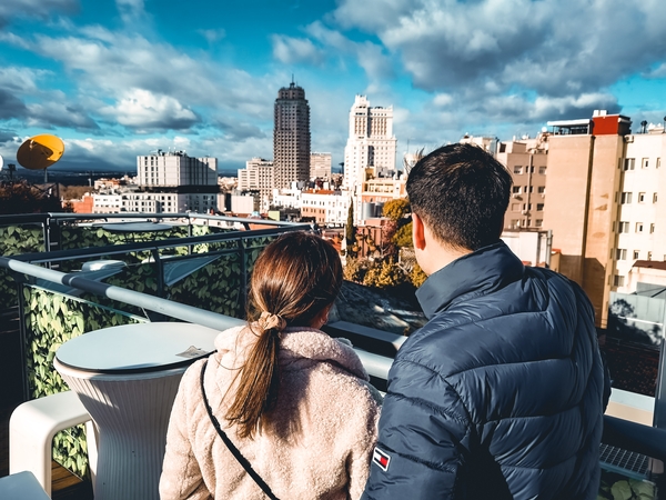 Date Ideen im Herbst - dein umfassender Guide für romantische & aktive Momente in der Schweiz Paare, Hochzeitsblog Date-Ideen Herbst: Paar geniesst die Aussicht von einer Rooftop-Terrasse über die Stadt.